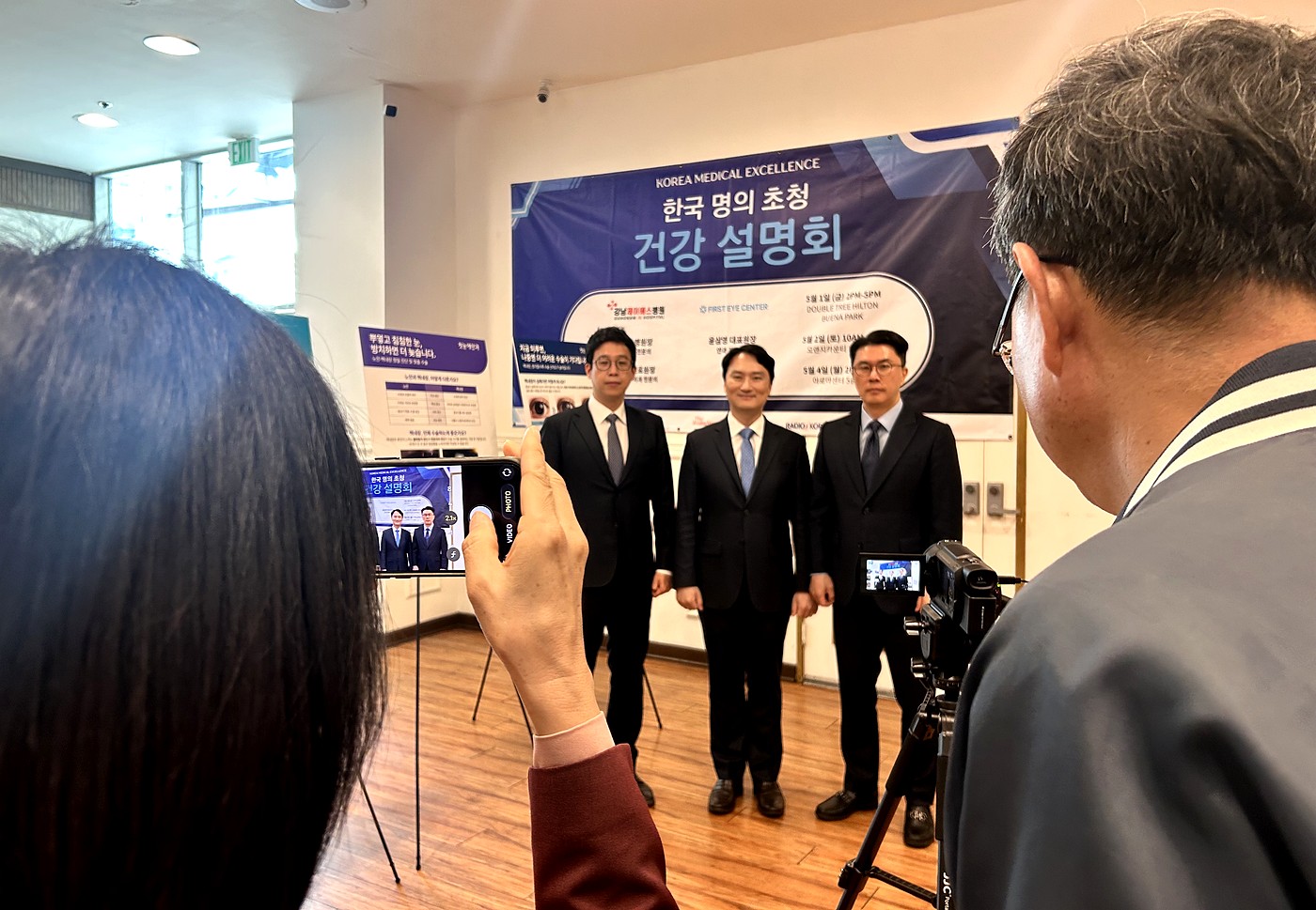 건강설명회 백드롭 앞에 선 초청 의료진